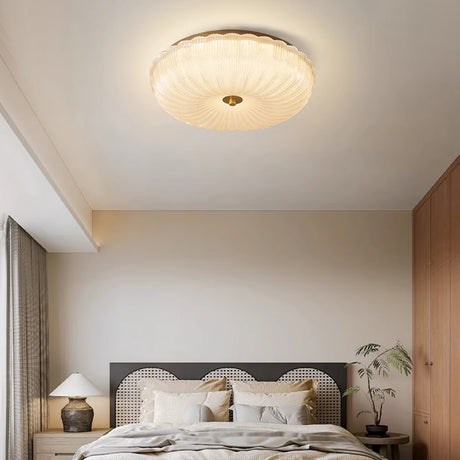 Halo ripple glass ceiling light installed and lit above a bed