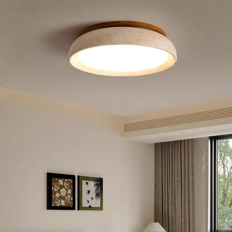 Kloris travertine ceiling light installed and lit in a bedroom